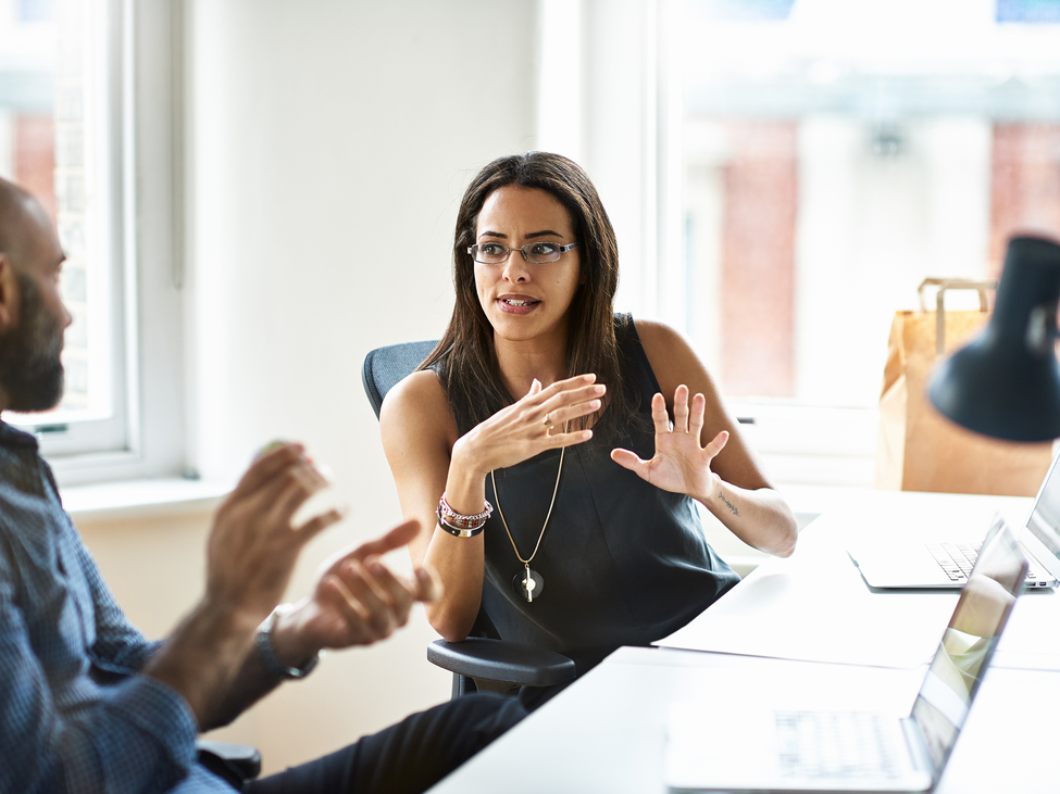 Tech sector professionals converse in an office setting.