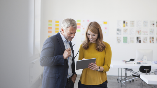 Two entrepreneurs ideate in an office conference room.