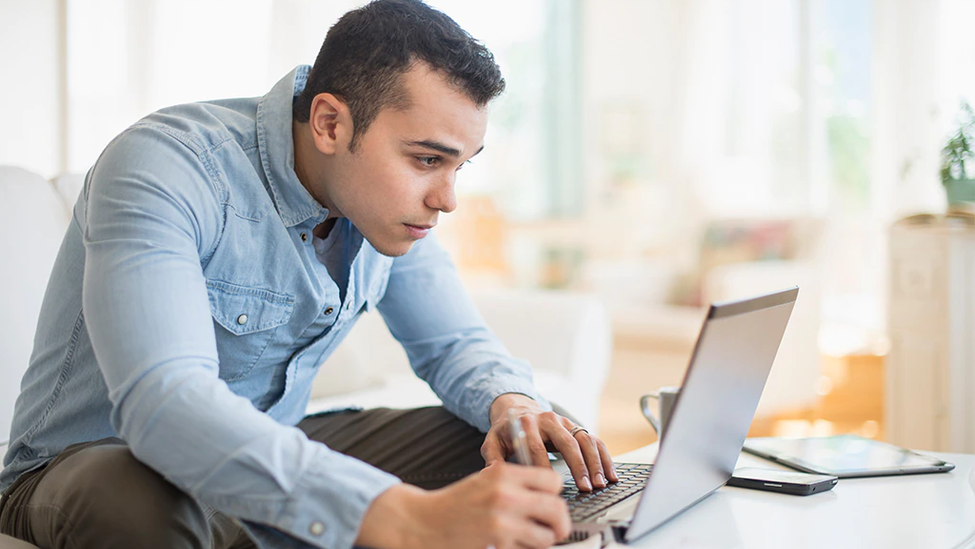 Man working on computer in living room.