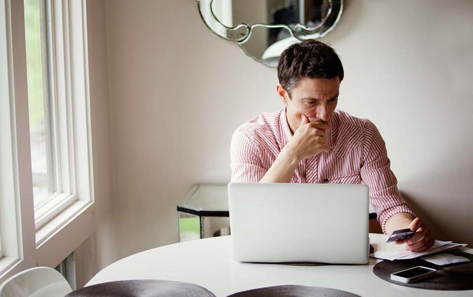 Man worried about identity theft looking at laptop.