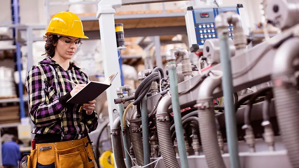 Manufacturing employee inspecting equipment.