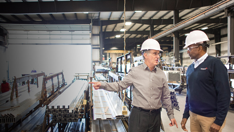 Travelers agent discussing manufacturing insurance with an employee in a warehouse.