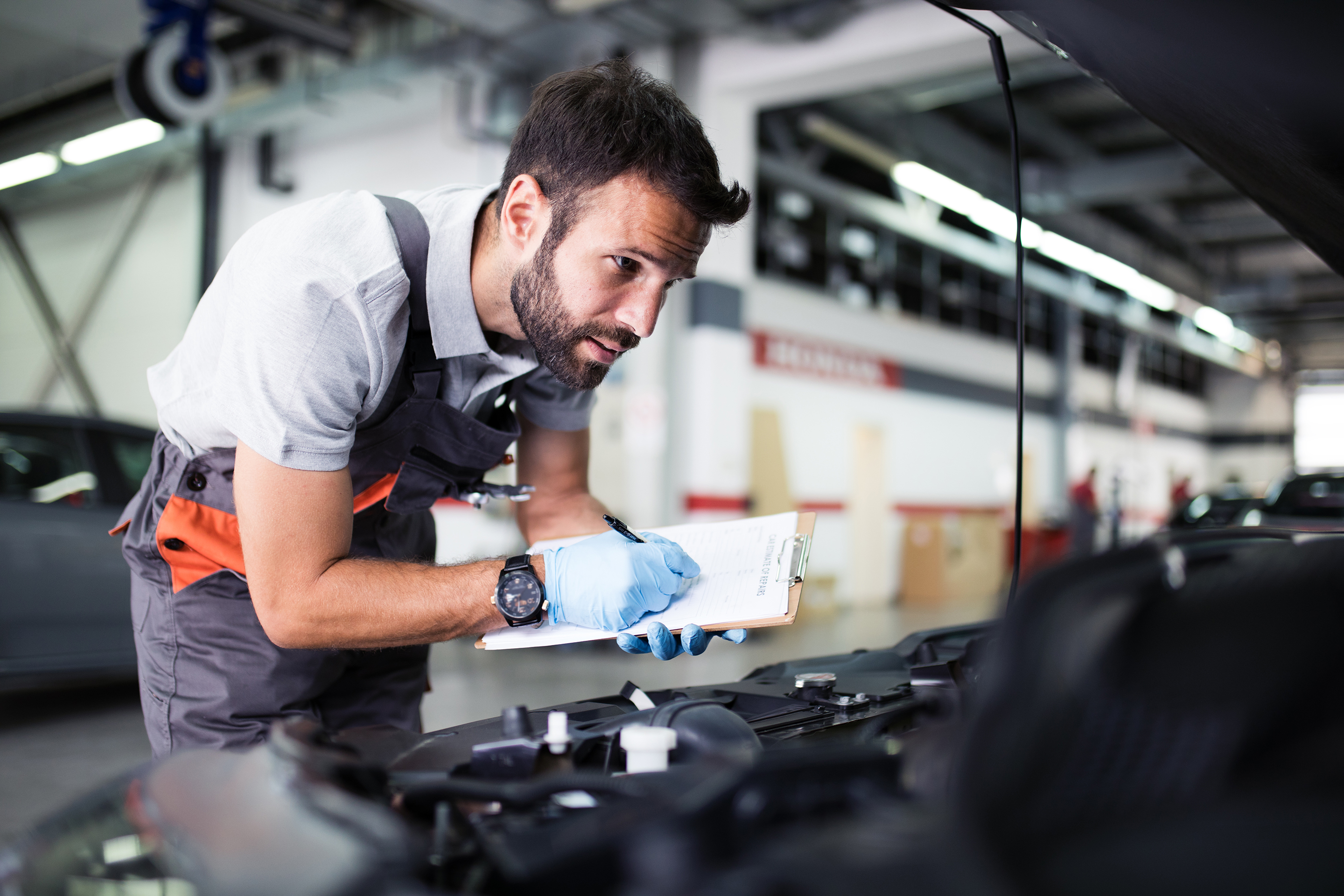 Mechanic inspects vehicle to calculate an auto repair estimate.