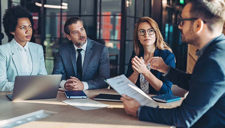 A group of business professionals having a meeting in an office setting.