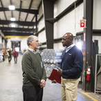 Men meeting in a warehouse.