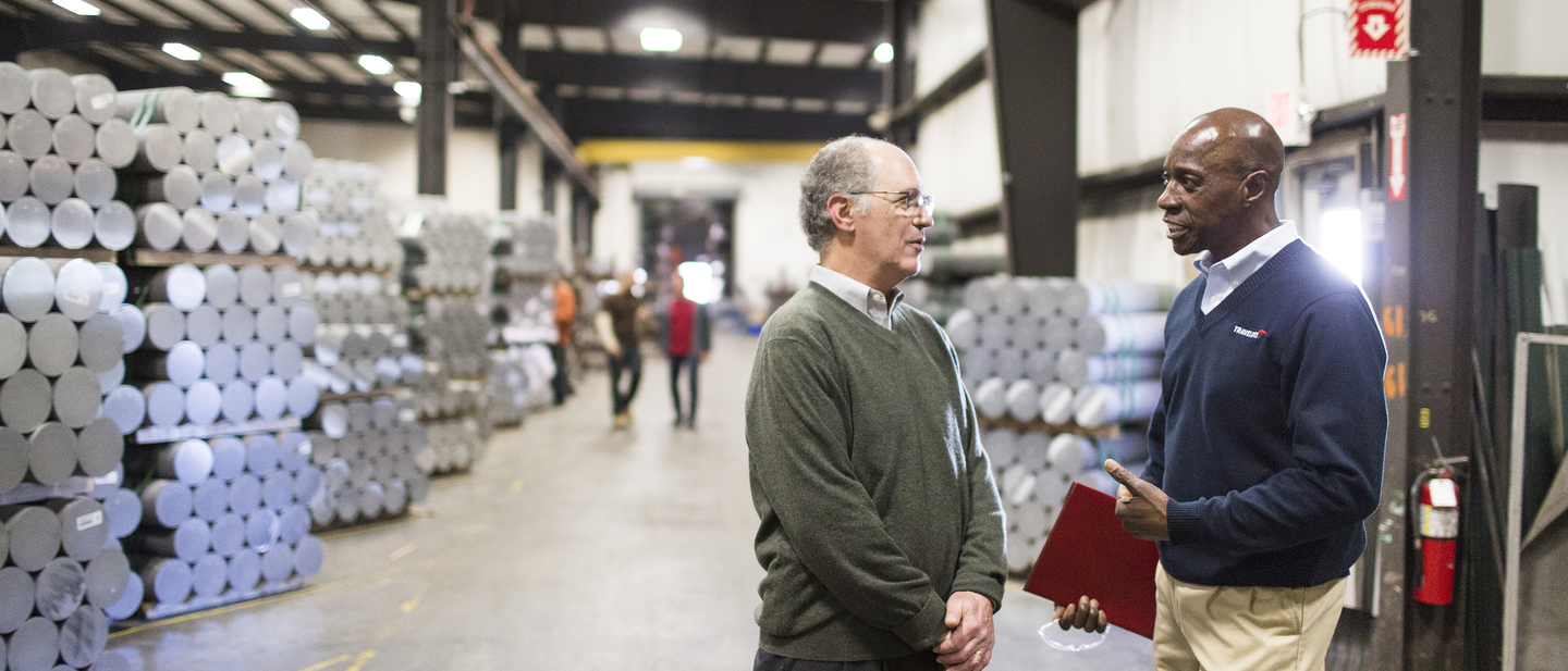 Travelers rep talking with warehouse manager in warehouse