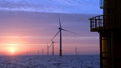 View of an offshore wind farm at sunrise.