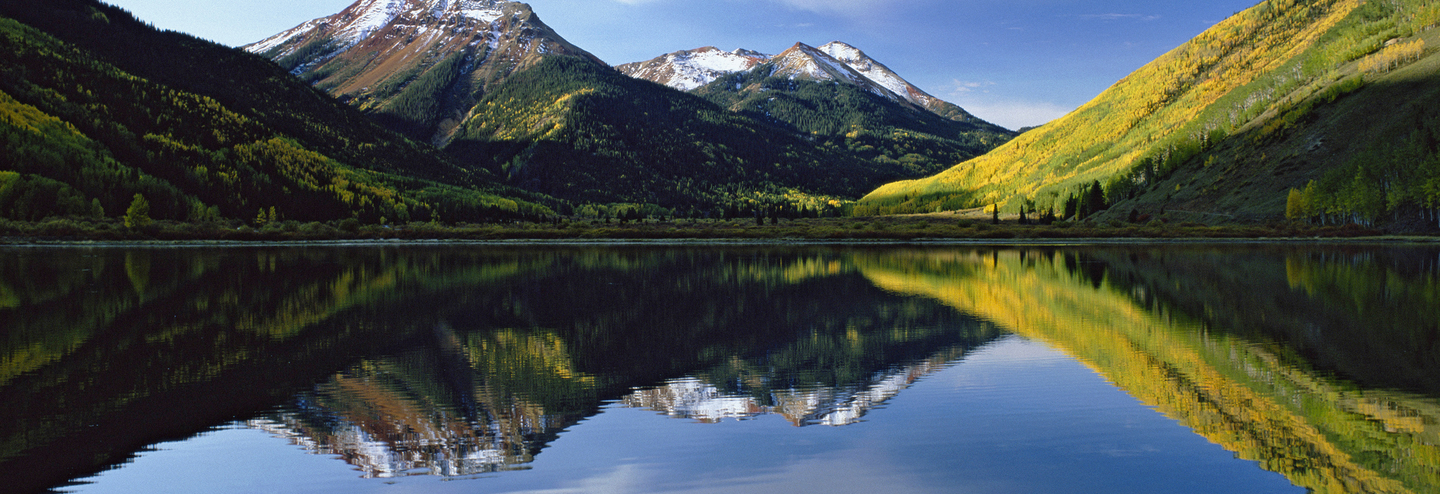 Mountains and sky reflected in a still lake.