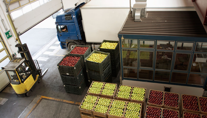 Truck driving next to open crates of fruit
