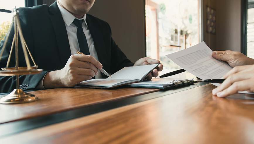 Lawyers looking over paperwork at a desk.