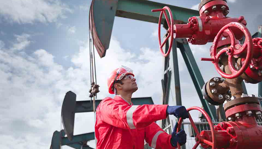 Oil and gas worker handling equipment.