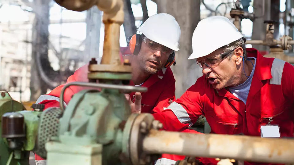 Oil and gas worker training new employee.