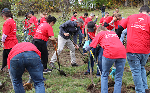 Travelers employees with shovels to plant trees, Go Paperless for a Purpose.