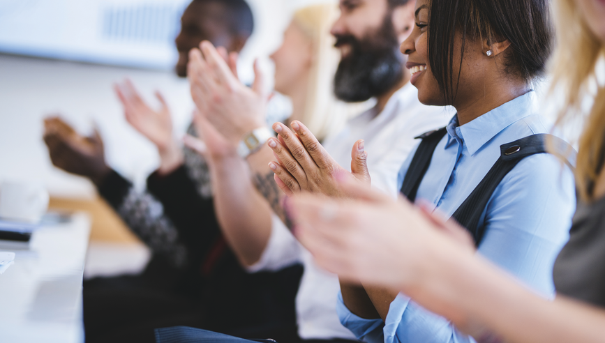 Shot of group of people clapping in a conference hall