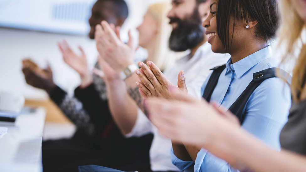 Shot of group of people clapping in a conference hall