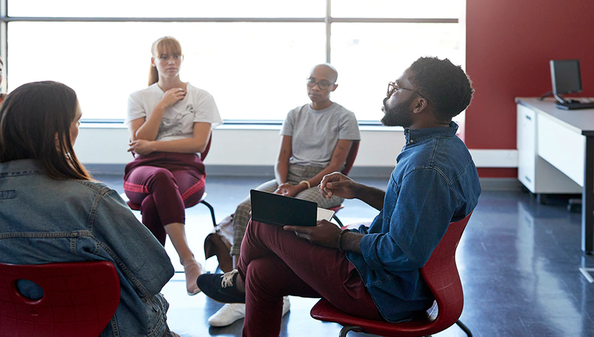 People gathered around a seated roundtable discussion.