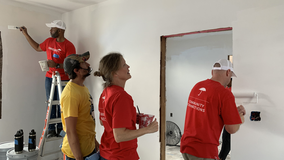 Travelers employees volunteering and painting a room