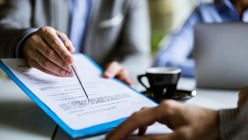 People pointing at a section of a contract.