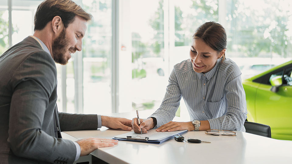 Person filling out paperwork to lease a car.