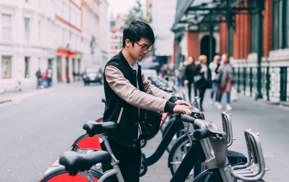 Person parking smart bike, as part of smart city transportation.