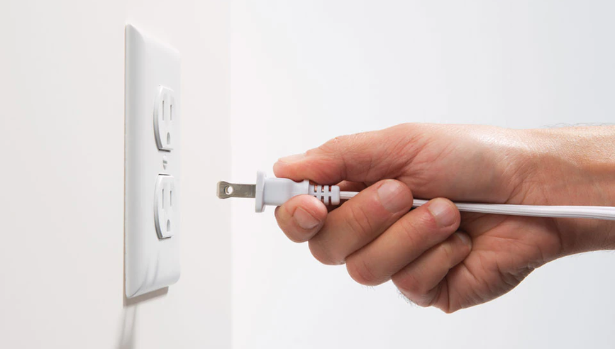 Person plugging cord into an outlet.