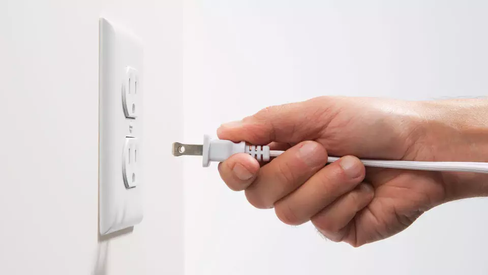 Person plugging cord into a safety outlet.