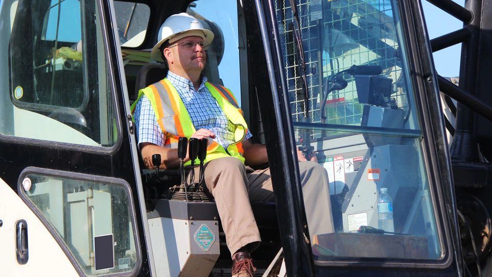 Person sitting in cab of construction vehicle.