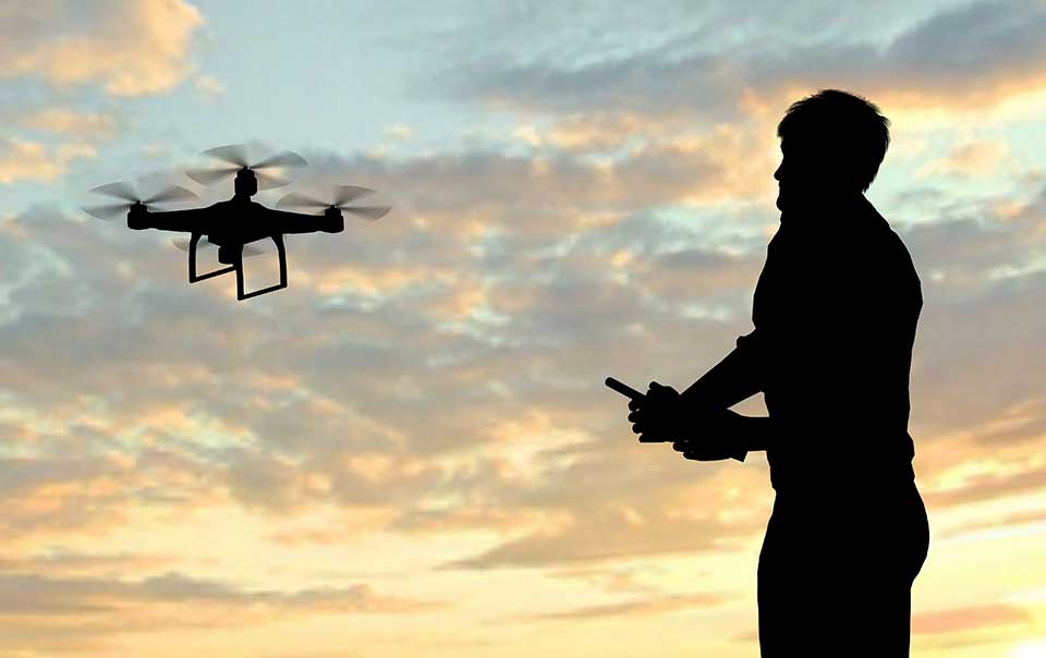 Person using a remote control to fly a personal drone.