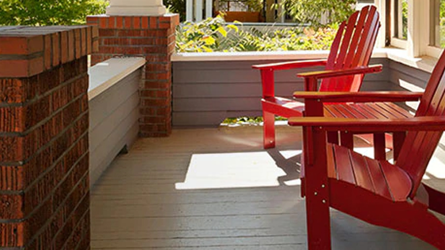 Red chairs on the front porch of a home.