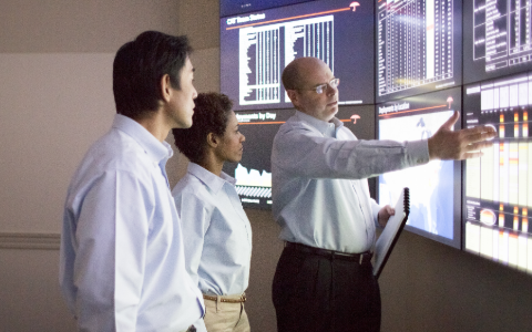 Three men in a command center preparing catastrophe response plans.