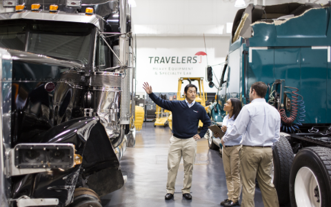 Employee explaining heavy truck damage to others in a heavy truck lab.