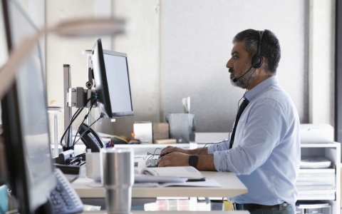 Man at standing desk giving loss consultation service.