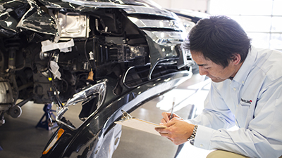 employee inspecting the car