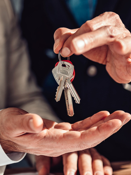 One person passing a set of keys to another, who's holding out a palm.