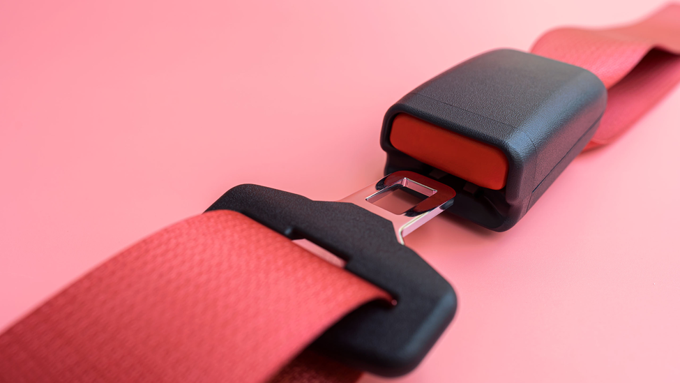 Closeup of a seat belt being buckled.