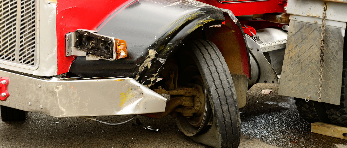 Red semitruck with a bent wheel from an accident