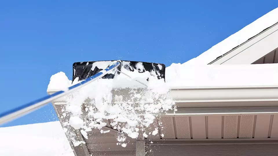 Removing snow safely from the roof.