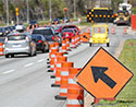 Road filled with traffic and orange traffic cones