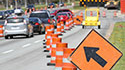 Road filled with traffic and orange traffic cones