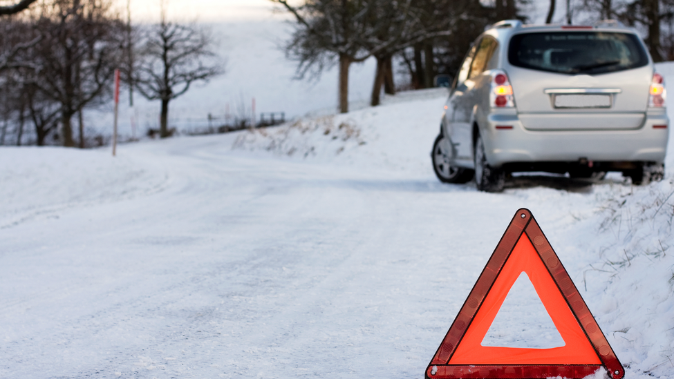 Car on the side of road in winter.