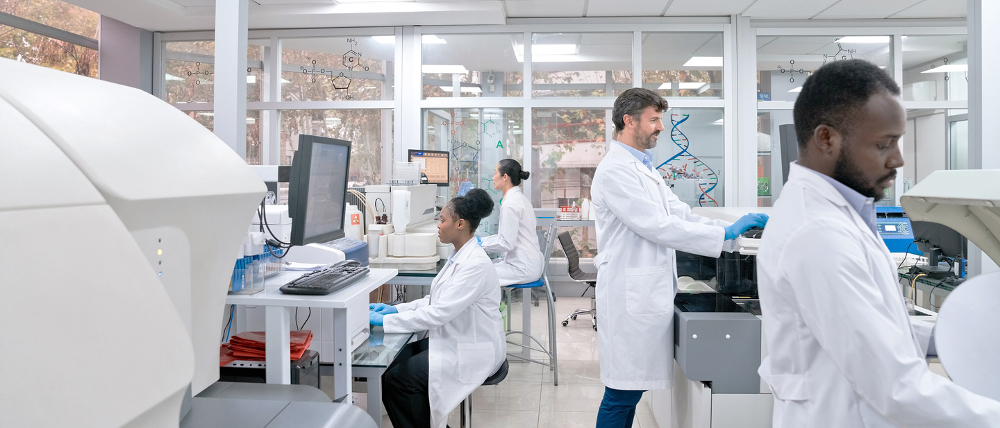 Scientists working together in a lab on advanced equipment.