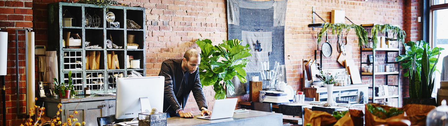 Small business owner manages his insurance online while in his shop.