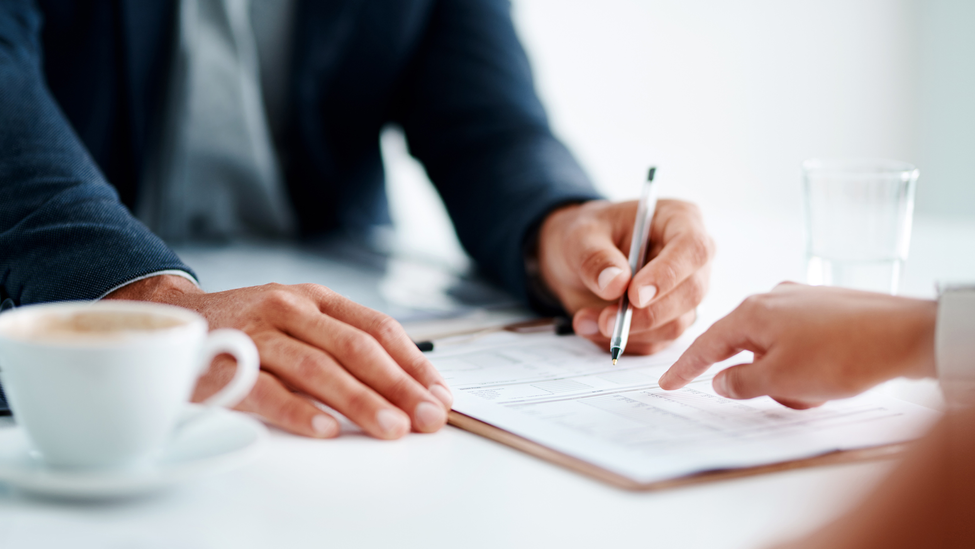 Closeup shot of two unrecognizable businesspeople going through paperwork together in an office