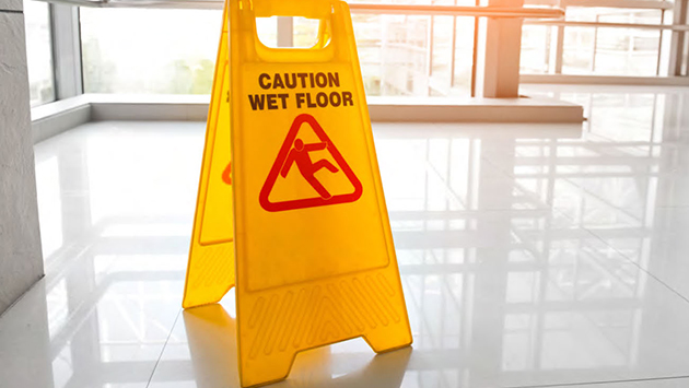 Slippery when wet sign inside a business lobby.