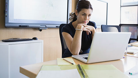 Organizational leader reads about cyberrisk in an office.