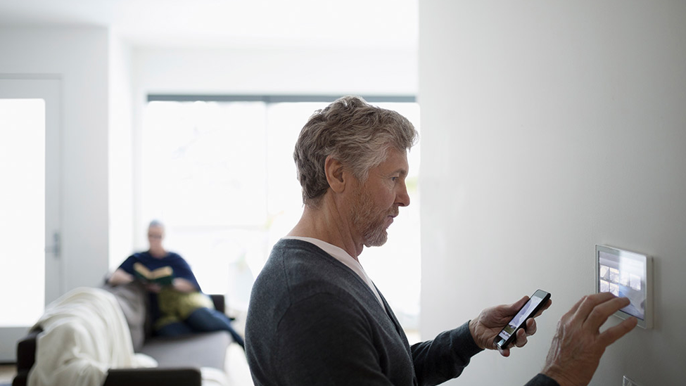 Man setting up smart technology to protect home.