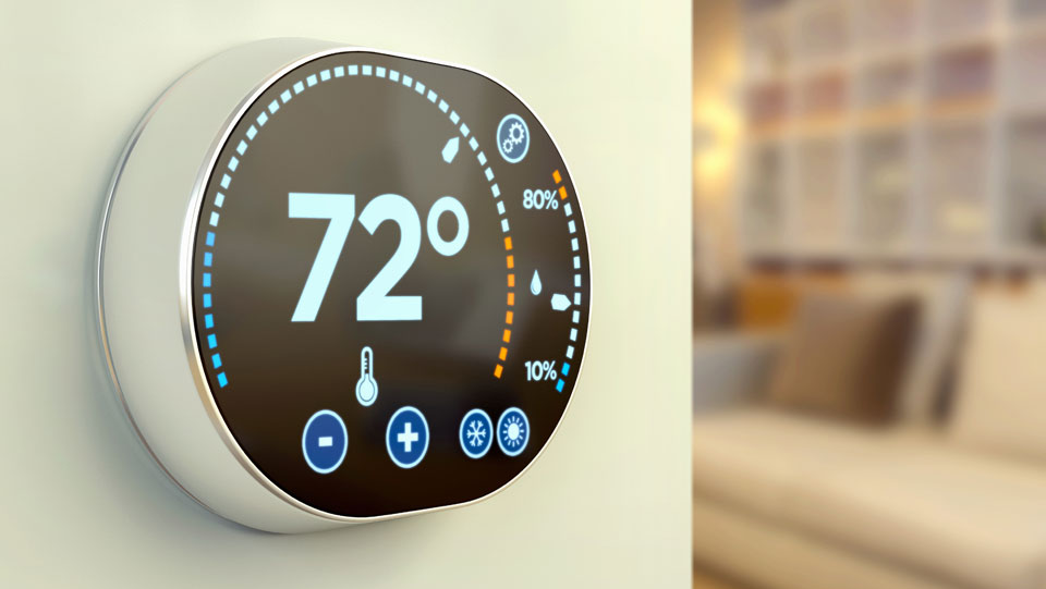 Smart thermostat on wall with temperature displayed.