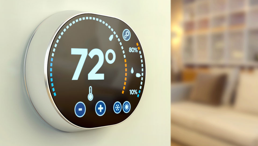 Smart thermostat on wall with temperature displayed.