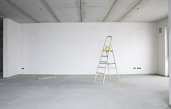 Ladder in front of a blank, white wall.