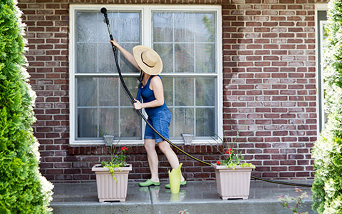 Woman cleaning windows in summer